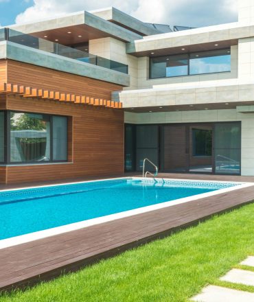 A stunning modern house with a spacious pool and green garden, ideal for relaxation.